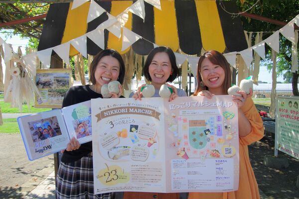 マルシェのポスターを持つ「はがめぐ」の３人