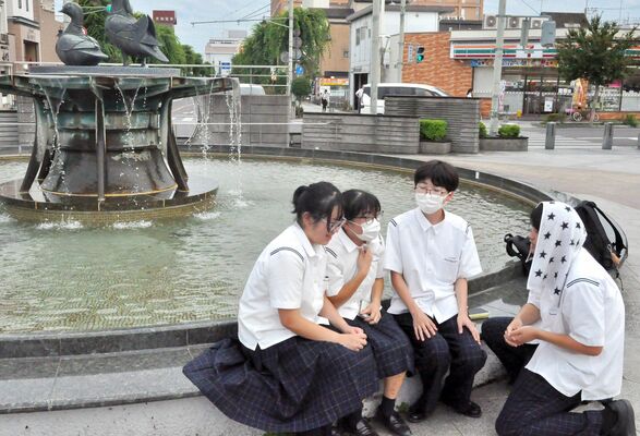 佐野駅の噴水前で涼む下校途中の高校生たち＝24日午後５時35分、佐野市若松町