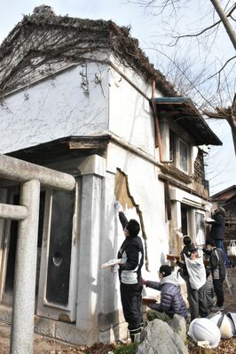 民泊施設となる土蔵の漆喰の中塗りに協力する市民有志ら
