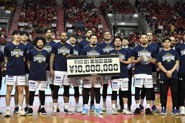 東地区優勝を決め、賞金ボードを掲げて笑顔を見せるブレックスの選手たち＝28日午後５時15分、千葉市中央区問屋町