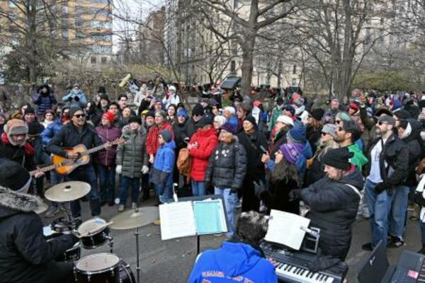 米ニューヨーク・セントラルパークの広場で、ビートルズのナンバーを合唱するファンら=8日(共同)