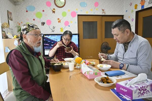 来所者と食卓を囲みながら会話する植村さん（左）