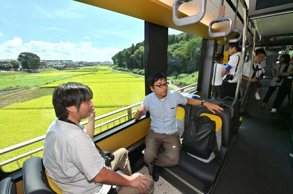 車窓から風景を眺める報道陣（超広角レンズ使用）
