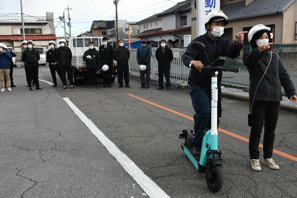 電動キックボードを体験する警察官＝１９日午後、宇都宮市陽南３丁目