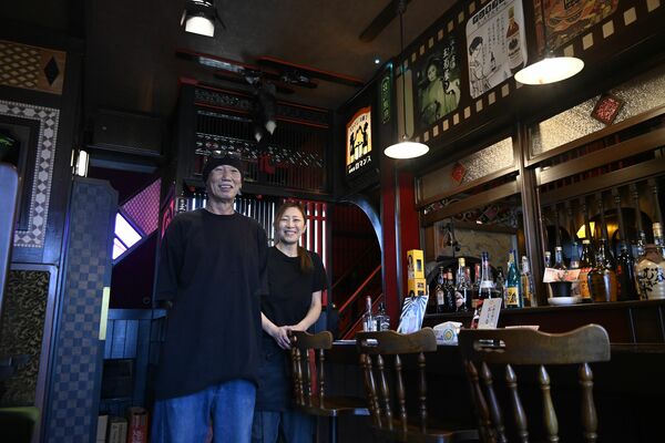 手作りの店内に立つ小山さん夫妻