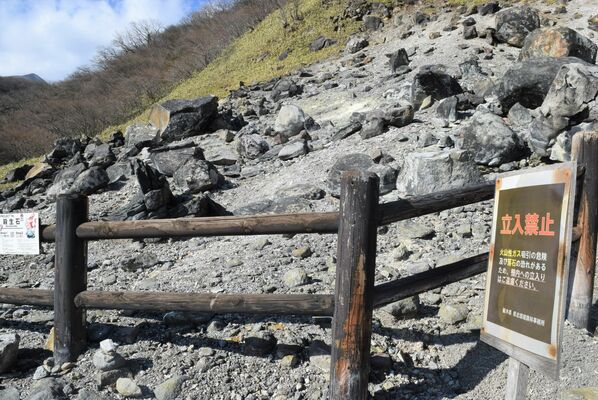 イノシシ８頭の死骸が発見された殺生石。柵の手前に有毒ガスへの注意を呼びかける看板が設置されている＝９日午後０時半、那須町湯本