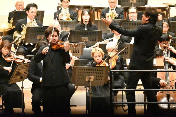 ブラームスのバイオリン協奏曲を演奏する三浦さん(左)と佐渡さん(右)=24日午後、県総合文化センター