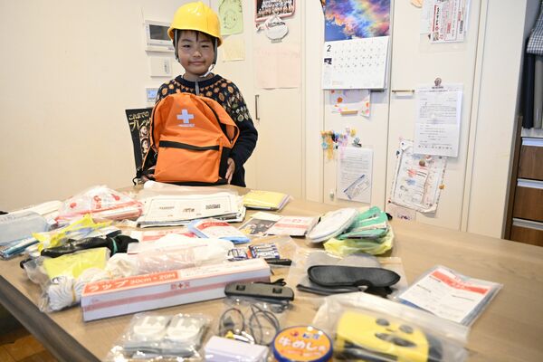 防災リュックを広げる蒼さん。基本のセットに必要な物を足しています
