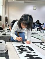 一筆に集中　「夢」にちなんだ作品仕上げる　席書大会に児童生徒55人