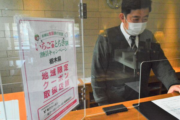 日光ステーションホテルクラシックの受付。全国旅行支援の案内が掲示されている＝13日午後、日光市相生町