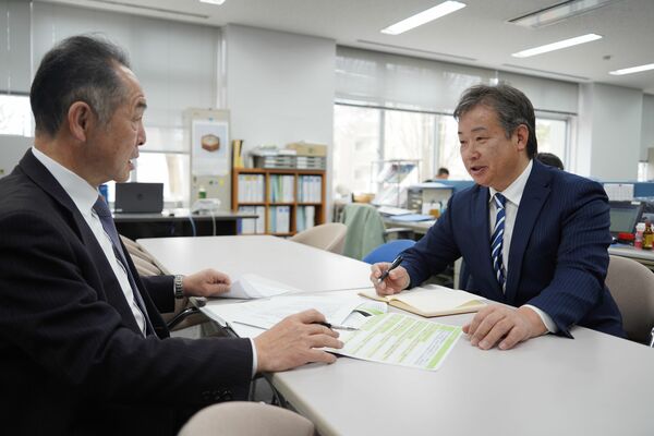 須田チーフコーディネーター（左）と打ち合わせをする見目参事＝４月上旬、宇都宮市
