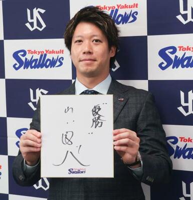 契約更改交渉を終え、記者会見で来季の抱負を記した色紙を掲げるヤクルト・山田=28日、神宮球場