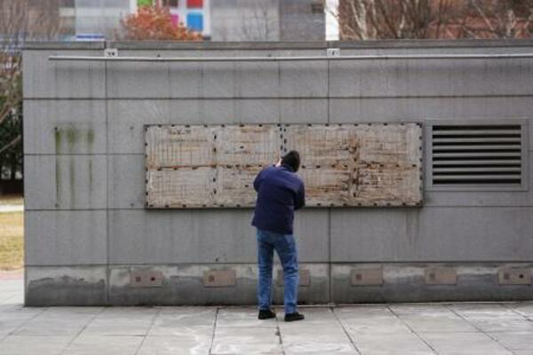 奴隷制を伝える展示物が撤去された場所を撮影する人=23日、米東部フィラデルフィア(AP=共同)