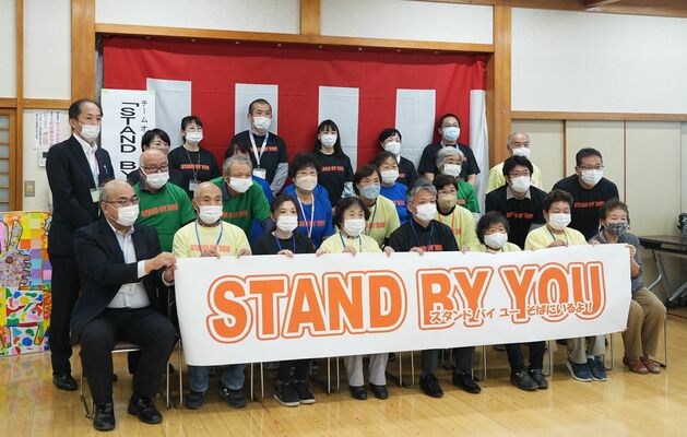 発足式でチームの横断幕を手にする関係者たち