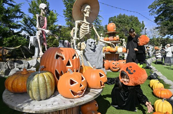 本格的なハロウィーン装飾を楽しむ仮装した親子連れ=15日午前11時30分、那須塩原市鹿野崎