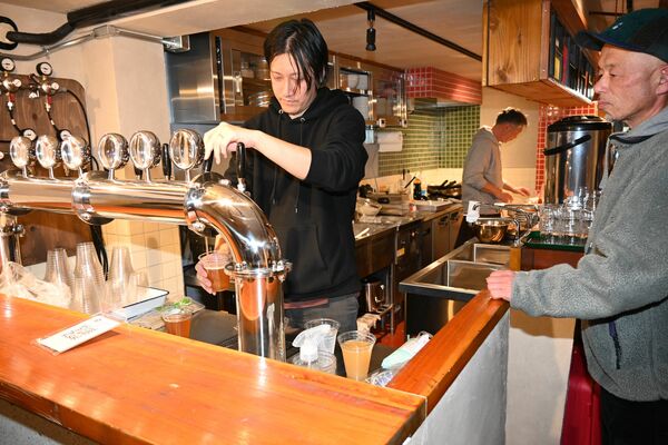 トラフトタワーからビールをカップに注ぐトリイ堂醸造所のブルワー＝２０日夜、鹿沼市