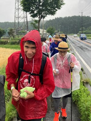 雨に打たれながらも元気に歩く生徒