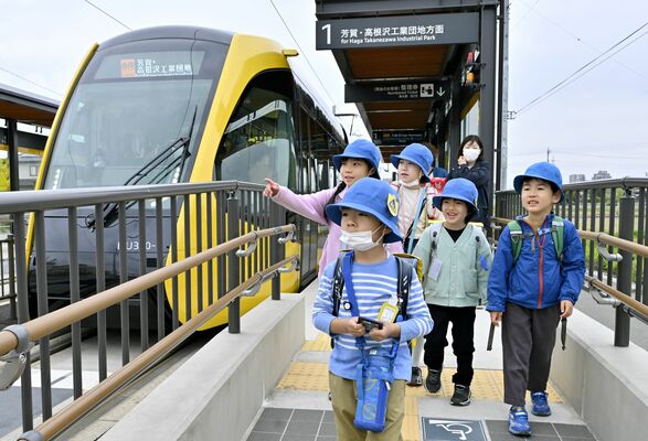 ＬＲＴに乗り、笑顔で登校する児童たち＝23日午前８時、宇都宮市下平出町