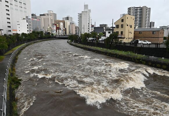 大雨で濁流となった田川＝24日午後２時55分、宇都宮市駅前通り１丁目