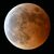 皆既食となり、赤銅色に染まる月。左下の青白い光は天王星＝８日午後８時15分、下野新聞社本社屋上（超望遠レンズ使用）