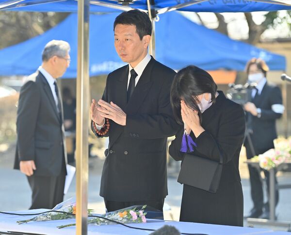 大田原高での追悼式で手を合わせる遺族の奥勝さん（中央）＝22日午前10時25分、大田原市紫塚３丁目
