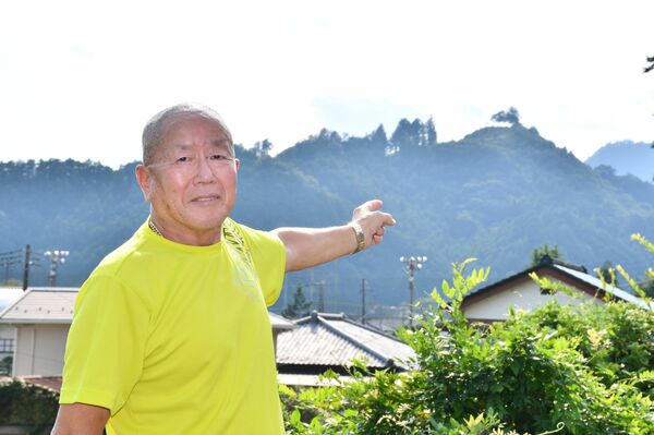庭先から監視哨があった城山山頂を指さす一男さん=13日午後、鹿沼市口粟野