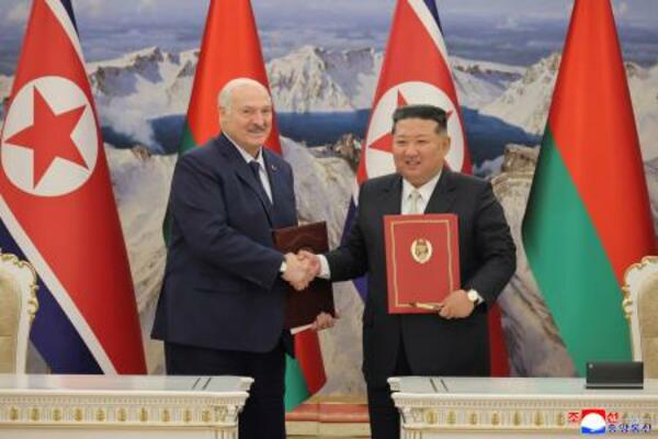 握手するベラルーシのルカシェンコ大統領(左)と北朝鮮の金正恩朝鮮労働党総書記=26日(朝鮮中央通信=共同)