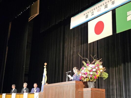 創立40周年式典であいさつする生徒会長の関谷さん(右)