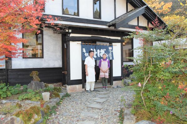 再開した店の前に立つ藤倉さん夫妻