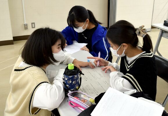 寺子屋大作戦で参加者に勉強を教える栗原さん（左）
