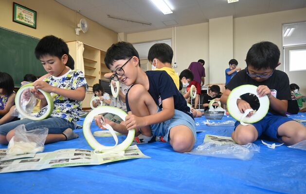手カンナを使いユウガオの実をむく子どもたち