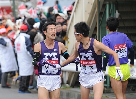 2015年の第91回大会で１区区間３位と好走し、たすきをつなぐ横手選手（左）＝2015年１月２日、横浜市鶴見区