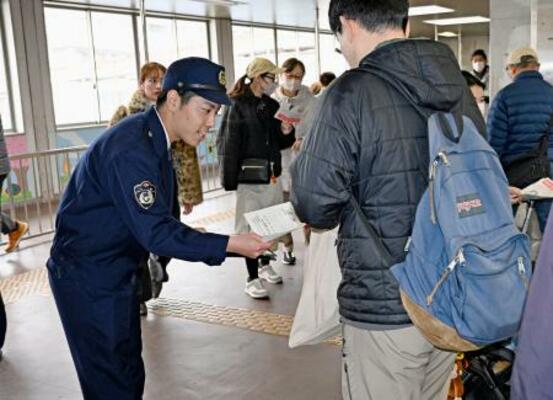 　ＪＲ都賀駅で情報提供を求めるチラシを配る千葉県警の捜査員＝１３日午前、千葉市
