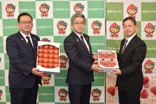 中村県本部長（中央）らからイチゴとトマトを手渡された石井校長（右）＝７日午前、宇都宮市