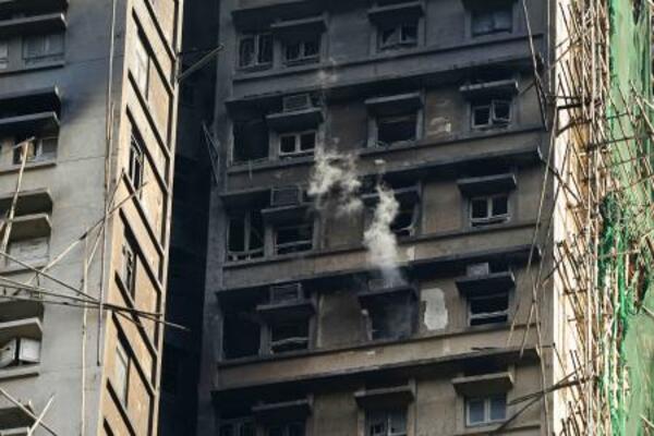 　消火活動が続く火災現場の高層住宅＝２８日、香港北部・新界地区大埔（共同）