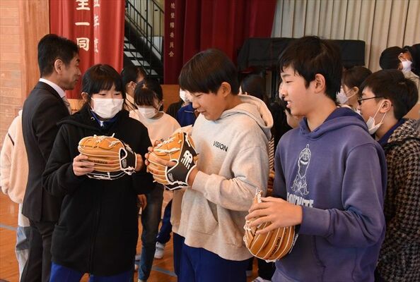 大谷選手から贈られたグラブの感触を確かめる児童