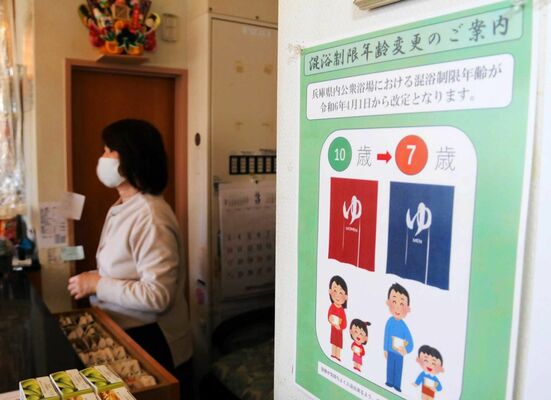 混浴制限年齢の変更を知らせるポスター。神戸市では４月から引き下げられた＝同市東灘区、湯あそびひろば森温泉