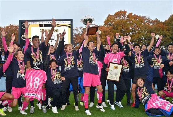 ＪＦＬ昇格を決め、優勝杯を掲げて喜ぶ栃木シティＦＣの選手ら＝26日午後４時、県グリーンスタジアム