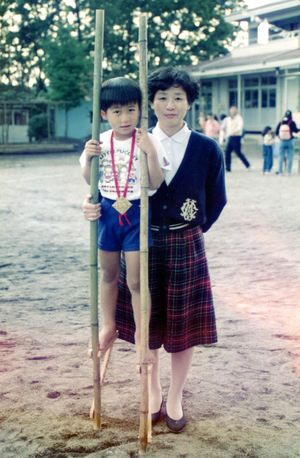 幼稚園で佳代さん（右）と記念撮影する竹馬に乗った大さん