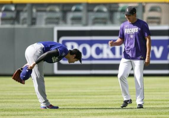 　４月２０日、試合前にロッキーズ・菅野（右）とあいさつを交わすドジャース・大谷＝デンバー（共同）