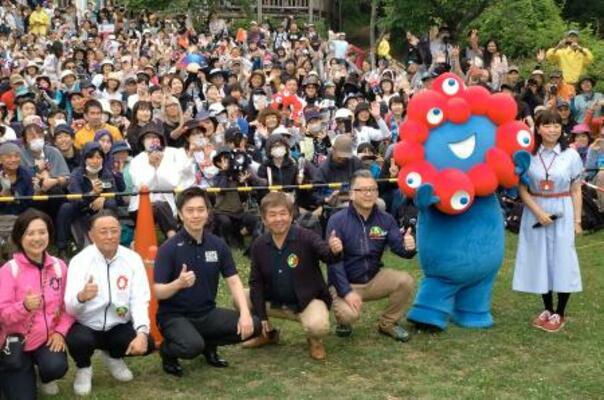 　「ちはや園地」で開催された大阪・関西万博の振り返りイベントで、公式キャラクター「ミャクミャク」と写真に納まる参加者ら＝３１日午前、大阪府千早赤阪村
