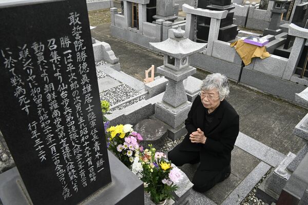 青木勝一さんが眠る墓に手を合わせる吉岡秀子さん＝26日午前11時、栃木市
