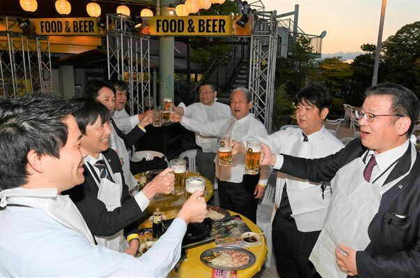 夕空を背にビールの入ったジョッキで乾杯する会社員ら＝27日午後６時15分、宇都宮市宮園町