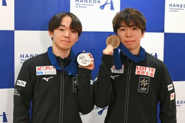 　メダルを手に撮影に応じる鍵山優真（左）と佐藤駿＝３１日、羽田空港