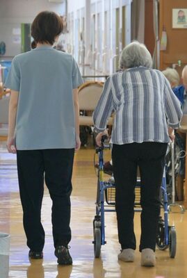 介護施設で利用者（右）に付き添う職員。参院選では各政党が処遇改善を掲げる＝６月下旬、宇都宮市
