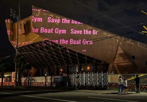 旧香川県立体育館の外壁に投影された「Save the Boat Gym」のメッセージ=5月、高松市