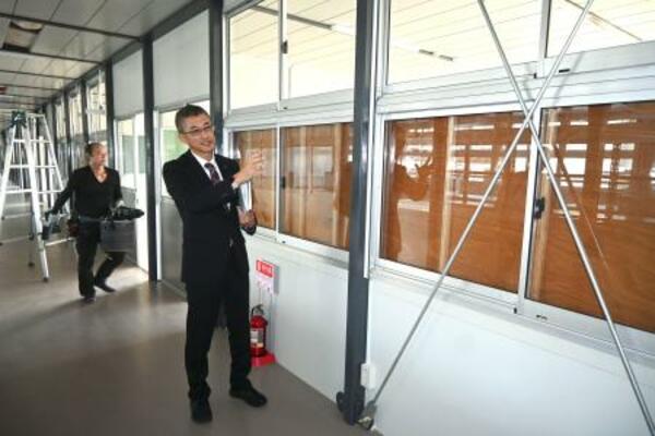 石川県立輪島高の仮設校舎内で話す高橋潤哉教頭=4日午後、輪島市