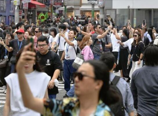 スマホを手にスクランブル交差点を行き交う人たち=東京・渋谷