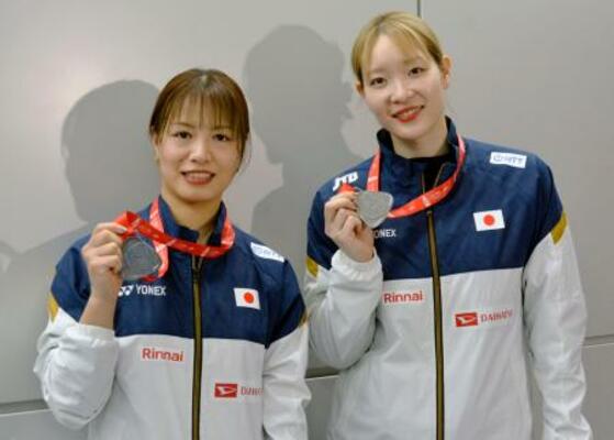 　メダルを手に写真に納まるバドミントン女子ダブルスの福島由紀（左）と松本麻佑＝２２日、成田空港
