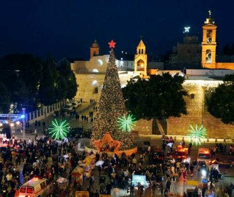 　イエス・キリスト生誕の地とされるパレスチナ自治区ベツレヘムで、クリスマスツリーが飾られた広場に集まった市民ら＝２４日（共同）